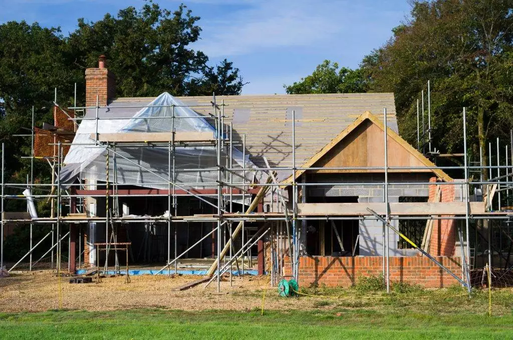 A family home under construction. A building site with scaffolding.